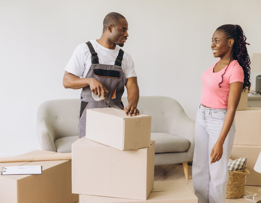 African American movers packing boxes in new apartment